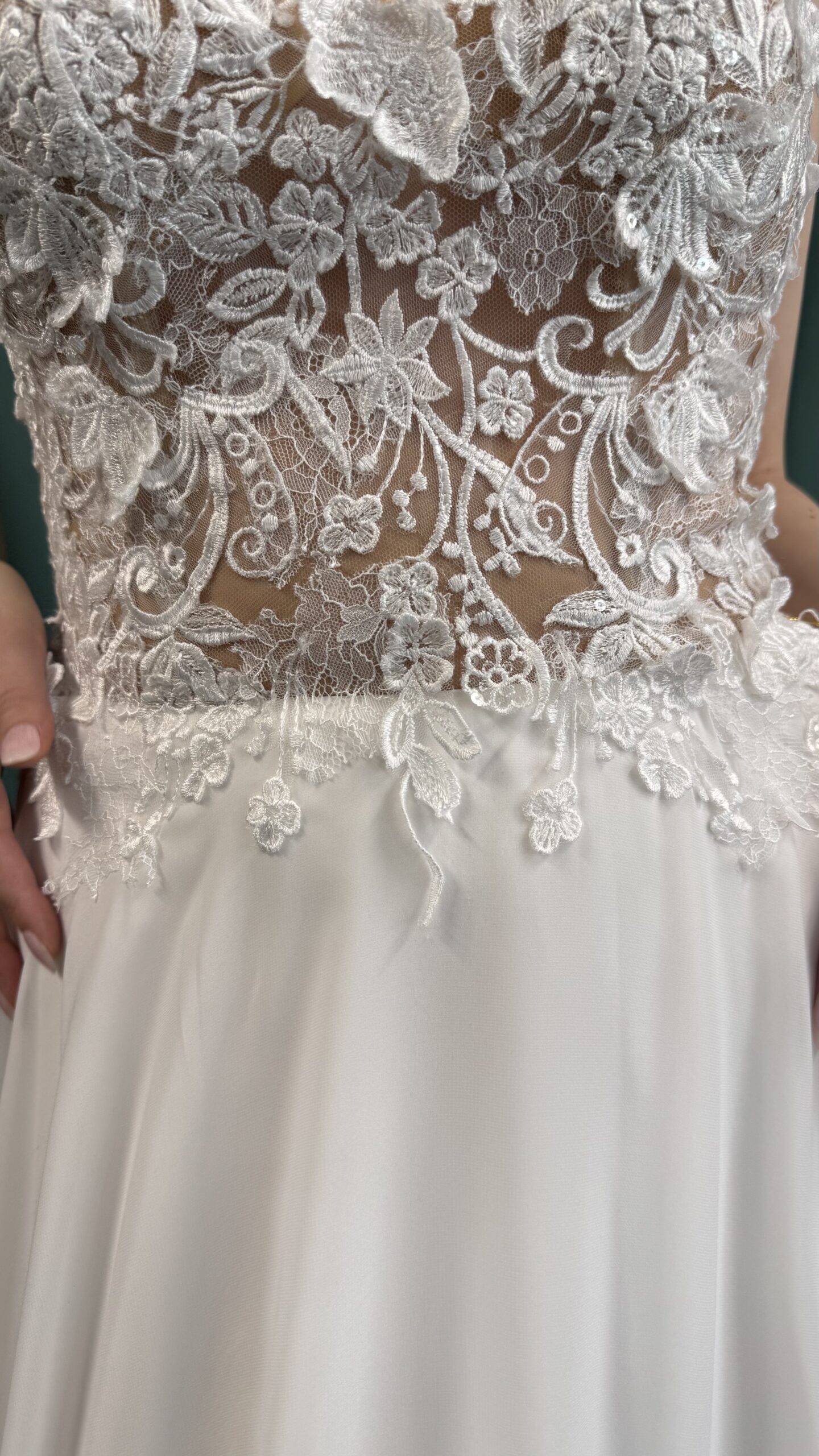 Braut vor grünem Hintergrund in Spitzenbrautkleid