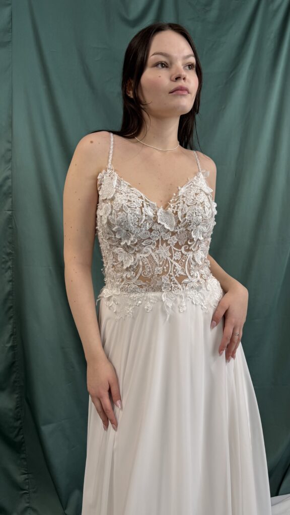 Braut vor grünem Hintergrund in Spitzenbrautkleid