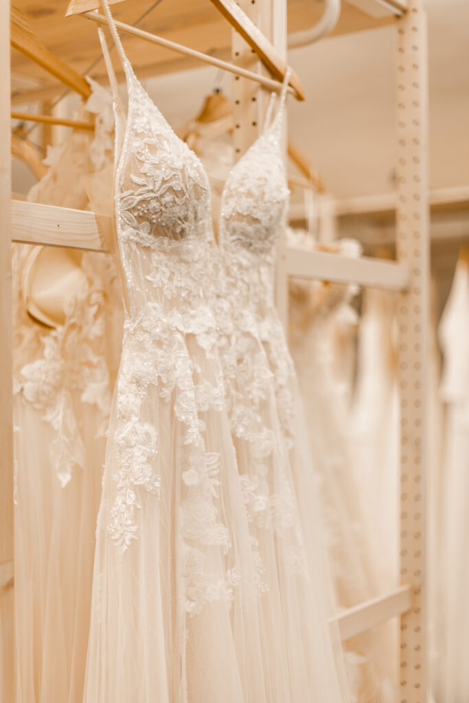 Preloved Brautkleid, hängt vor der Kleiderstange im Atelier. Trägerkleid mit feiner Blütenspitze und A-Linie.