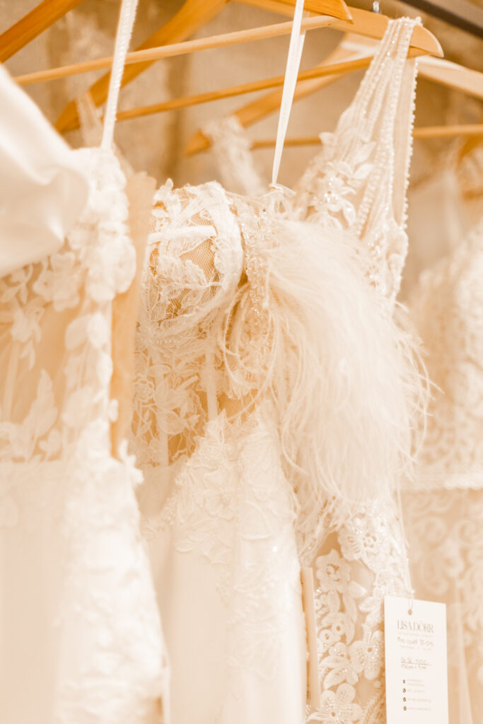 Nahaufnahme von drei Preloved Brautkleidern. Trägerkleider mit Spitze überzogen und Chiffon/Tüll Röcken. Etikett Lisa Dörr Unique Bridal Concept zu sehen.
