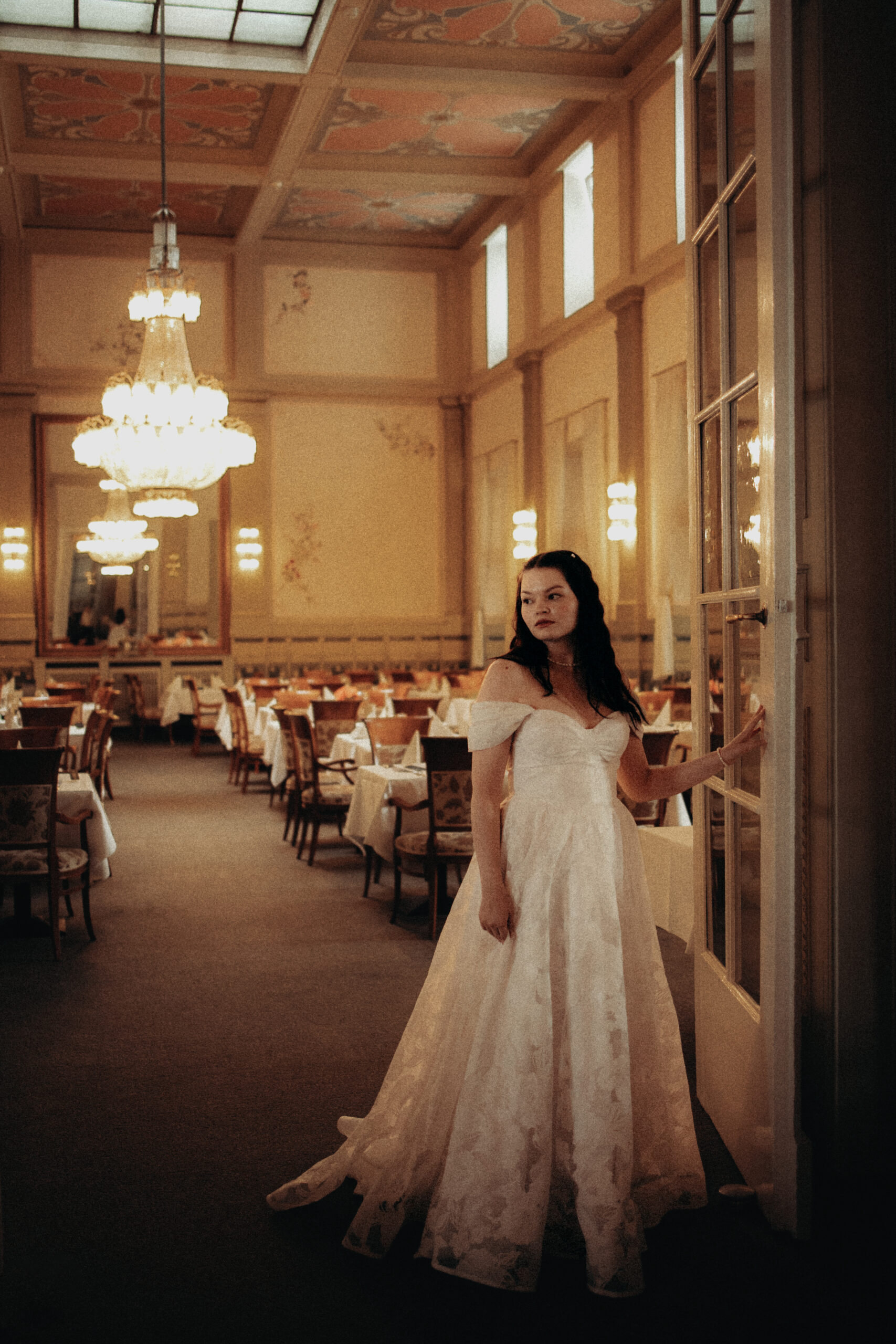 Braut im Saal des Grand Hotels Kaiserhof Victoria in Bad Kissingen, im Brautkleid Elara, große Blütenspitze mit Herzcorsage